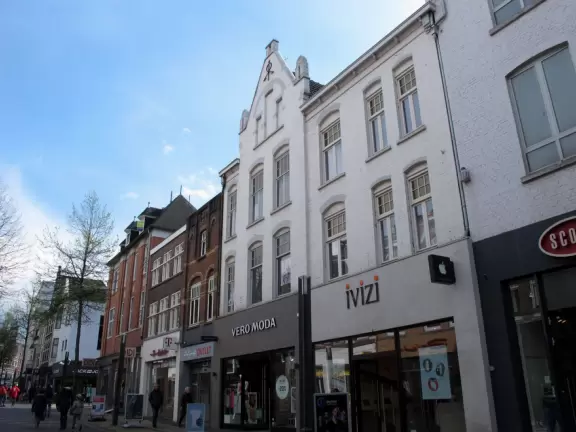 Town center with historic storefronts, large square, stone church, and outdoor cafes with flowerboxes.