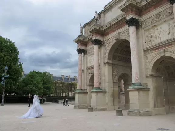 Spacious public garden with toy boats in the pond, rows of groomed chestnut trees, statues, carousel, and playground.