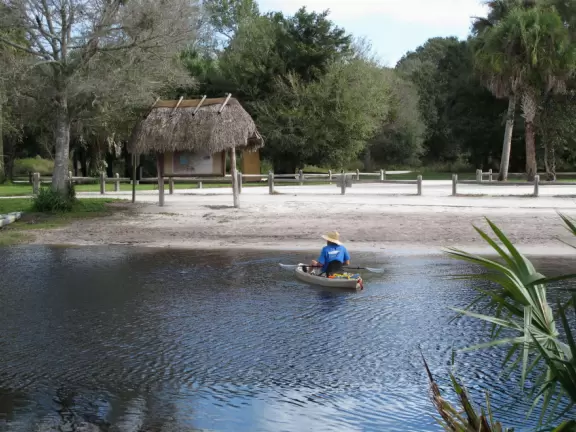 Tropical paradise with amazing trees, soft green grass, and woven huts shading picnic tables with BBQs that line the river, plus bike and kayak rentals. Beware alligators.