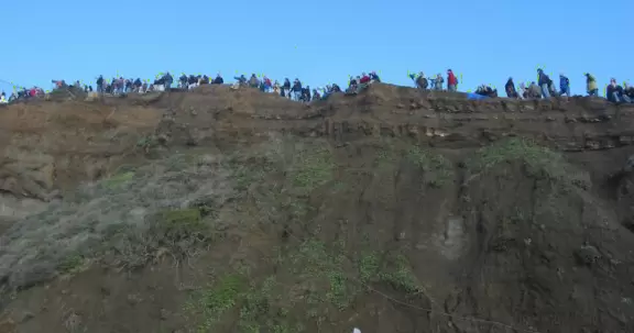 The vertical cliffs of mud, where trusting folks gather to get a better view of the waves. 