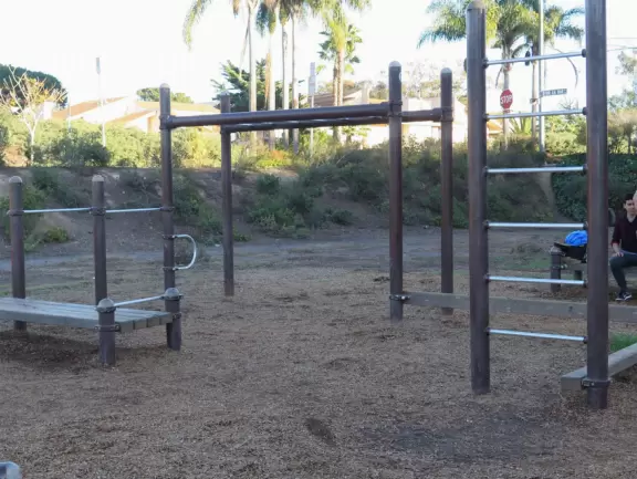 Park with calisthenics equipment and a playground.