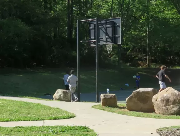 Large shady playground with two cool spinners, beach volleyball court, basketball court, and long bike path along a beautiful creek.