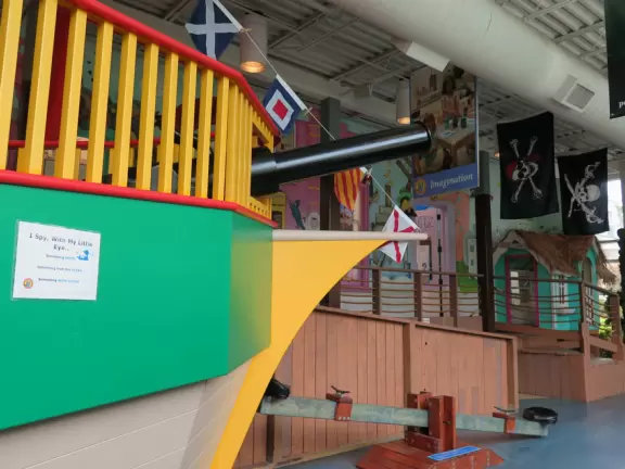 Large children's museum with ship with cannons, play houses, market and diner.