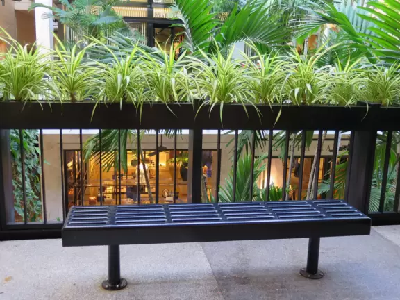 Ultra rich outdoor mall with gorgeous plants, fountains, sculptures, and flowers.