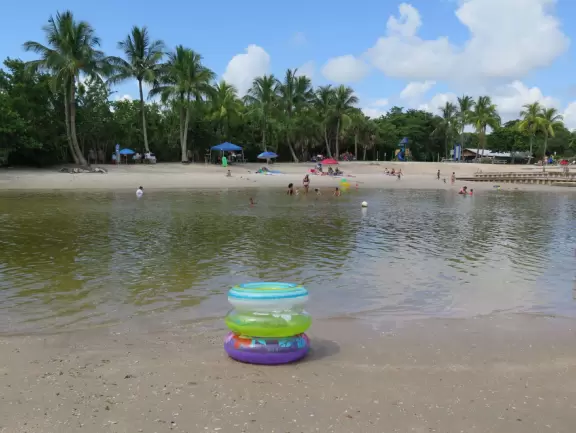 Large lagoon with clear water where kids can swim, tons of shade, and playground in the sand.