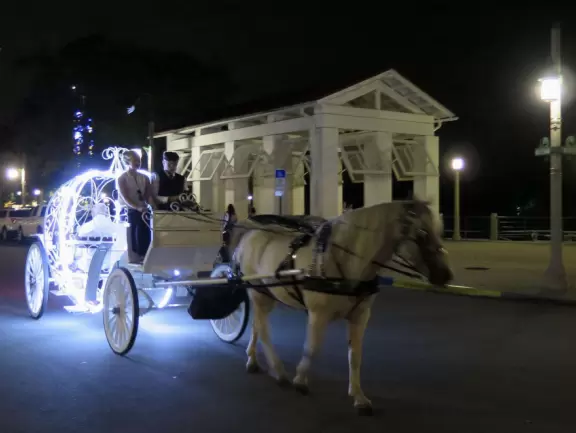 A popular town center with sidewalk cafes leading down to a pretty lake with a walking path.