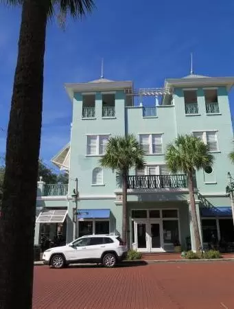 A popular town center with sidewalk cafes leading down to a pretty lake with a walking path.