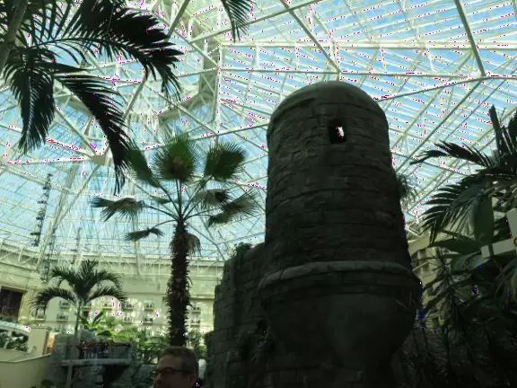 Hotel inside a giant atrium with tropical plants, fish, alligators, and decorations. ICE sculpture event in December.