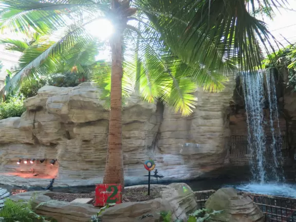 Hotel inside a giant atrium with tropical plants, fish, alligators, and decorations. ICE sculpture event in December.