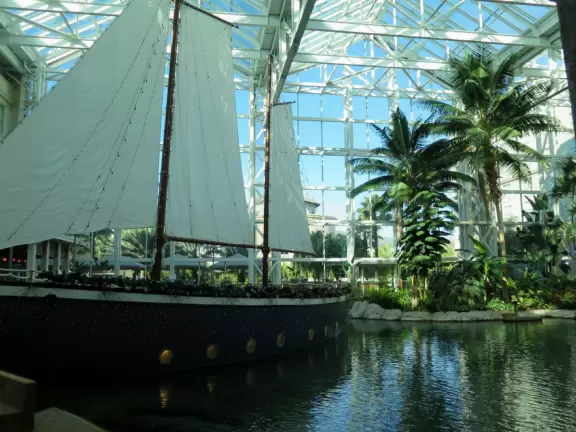 Hotel inside a giant atrium with tropical plants, fish, alligators, and decorations. ICE sculpture event in December.