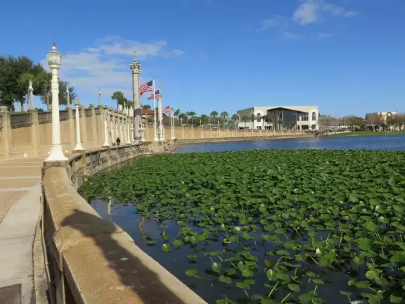 Beautiful garden with many partitioned areas, tropical plants, flowers, all with the blue lake behind. Plus, promenade around the lake.