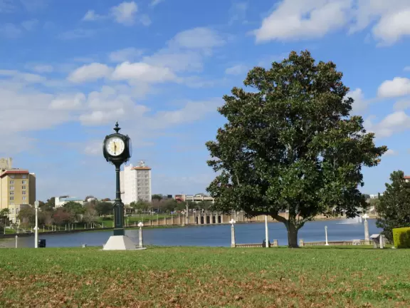 Perfect sky, clock, and magnolia tree, by a stretch of lawn along the Lake Mirror Walk.