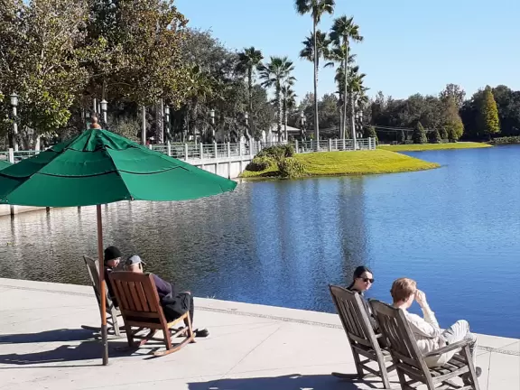 A popular town center with sidewalk cafes leading down to a pretty lake with a walking path.