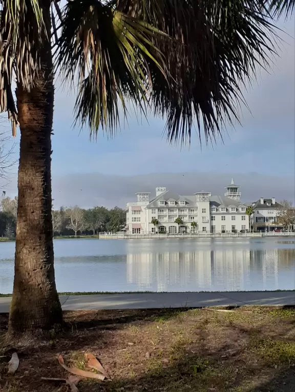 A popular town center with sidewalk cafes leading down to a pretty lake with a walking path.