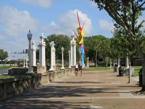 Beautiful garden with many partitioned areas, tropical plants, flowers, all with the blue lake behind. Plus, promenade around the lake.