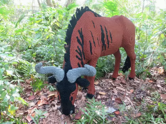 Lush paradise with water lilies galore, rustling bamboo, stone bridge, tropical flowers, strangler fig, and a gorgeous royal palm grove.