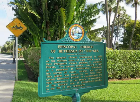 Delightful garden behind a gothic church, with lily pond, koi fish, tropical flowers, sculpted coral walls, fountain, and fresco.