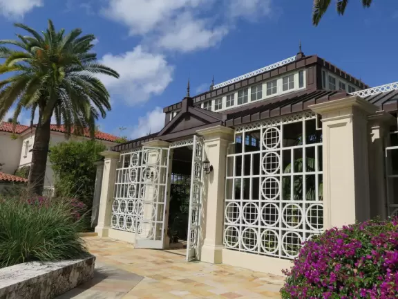 A tropical wonderland of palms, ferns, bromeliads, fountains, sculptures, rocks, ironwork gates, and pergolas, with the delightful scent of flowers filling the air.
