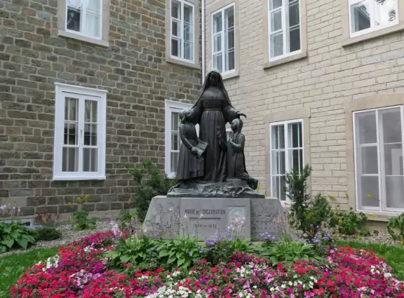 Very crowded street of historic buildings with restaurants and hotels, leading down to Chateau Frontenac.