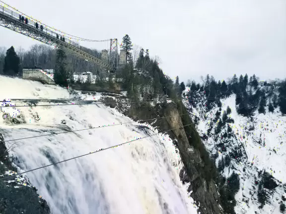 Tall waterfall at the mouth of the Montmorency River. You can walk stairs up to a suspension bridge over the falls.