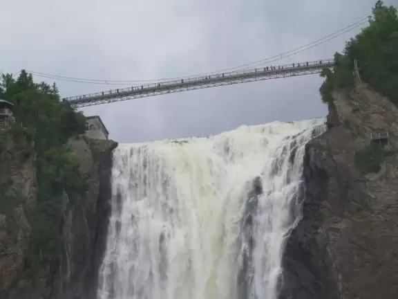 Tall waterfall at the mouth of the Montmorency River. You can walk stairs up to a suspension bridge over the falls.