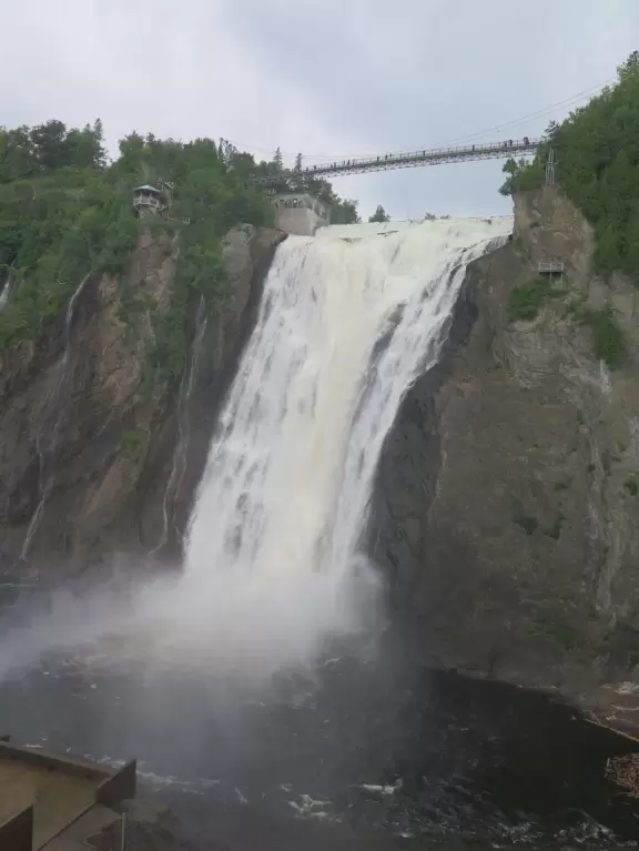 Tall waterfall at the mouth of the Montmorency River. You can walk stairs up to a suspension bridge over the falls.