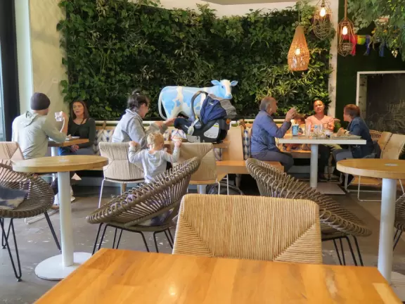 Shopping plaza with a deck offering lots of attractive public space, a trampoline for young kids, a sky deck bar, a dark public market with lights, cafes, stores and coffee shops.