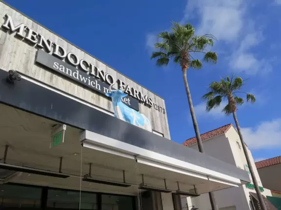 Shopping plaza with a deck offering lots of attractive public space, a trampoline for young kids, a sky deck bar, a dark public market with lights, cafes, stores and coffee shops.