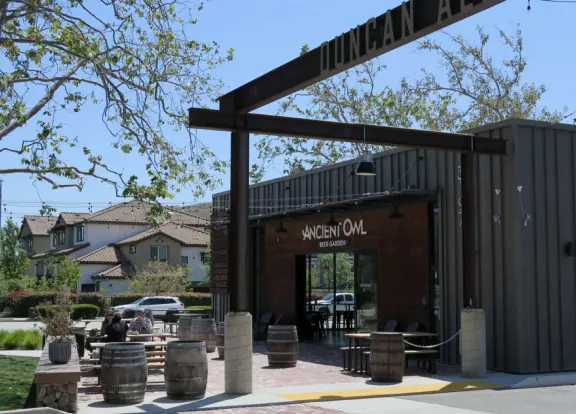 Trendy area with coffee shop, beer garden, wine bars, and cider bar, in industrial-style architecture with murals.