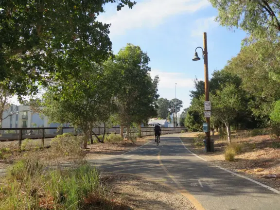 Bike path with views of hills all around, and pretty neighborhood nearby.