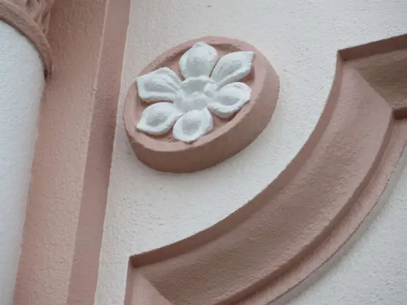 Breezy light-filled church with pink and white exterior, vintage lampposts, and bright stained glass windows.