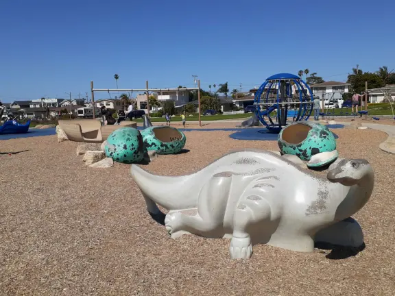 Imaginative playground with dinosaur eggs, huge green lawn, high hills in the distance, and path along the cliffs with views of the ocean and bird rocks!