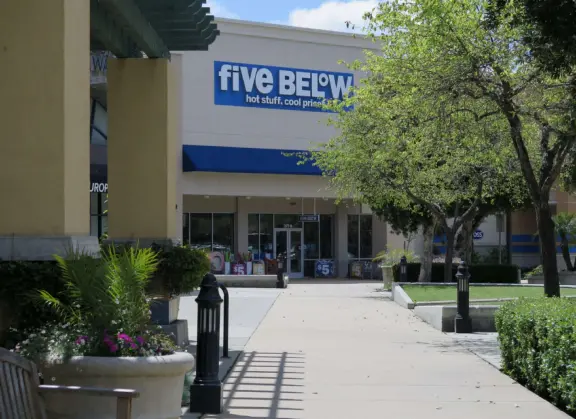 An outdoor shopping plaza with many fun stores.