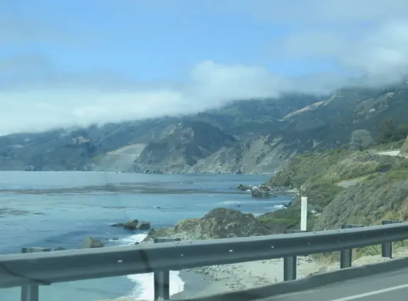 Stunning view from a bench on vertical cliffs above blue-green water.