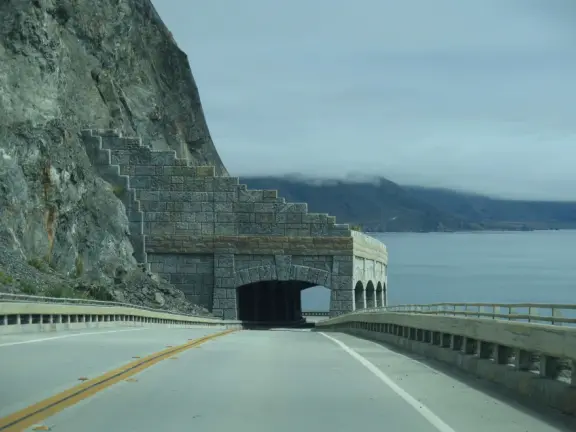 Stunning view from a bench on vertical cliffs above blue-green water.