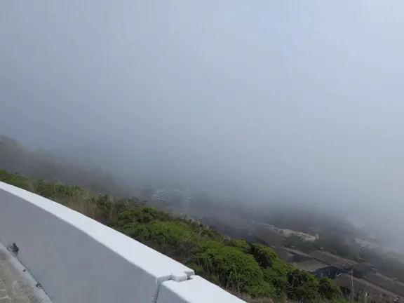 Views of sprawl, between two dry, barren hills. Steps to the top of each hill. Windy. Extremely foggy in the morning.