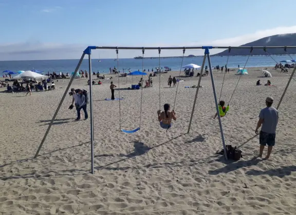 If you tire of the playground, you can swing on swings in the sand at the beach below!
