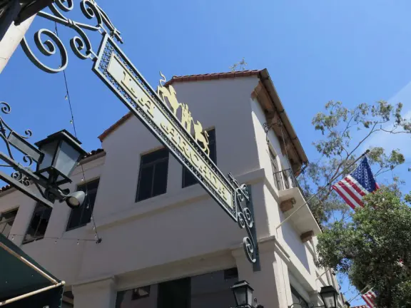 A Spanish paseo and courtyard with archways, little lights, flags, murals, lifelike statues, and fountains. At night, a magical spot!