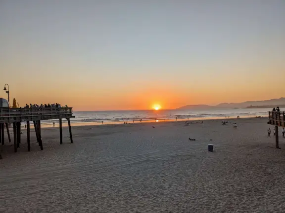 Gorgeous spot with wide pier, surfers carving the waves, whale playground, wide open attractive plaza, Pismo Beach selfie sign, and wooden promenade with views of the hills and sea.