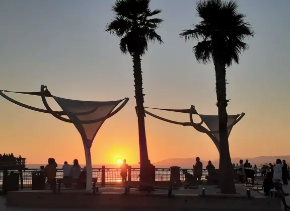 Gorgeous spot with wide pier, surfers carving the waves, whale playground, wide open attractive plaza, Pismo Beach selfie sign, and wooden promenade with views of the hills and sea.