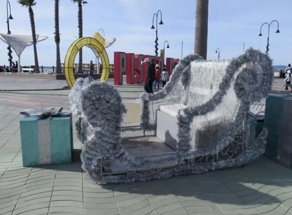 Gorgeous spot with wide pier, surfers carving the waves, whale playground, wide open attractive plaza, Pismo Beach selfie sign, and wooden promenade with views of the hills and sea.