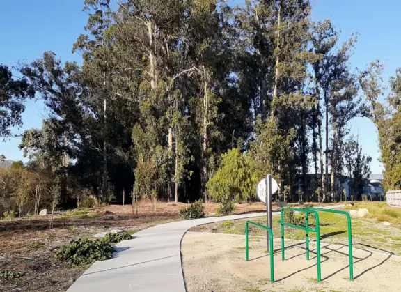 Lovely path beside a eucalyptus forest, on both sides of the creek, with workout stations, in a residential neighborhood.