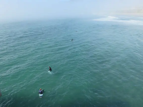 Gorgeous spot with wide pier, surfers carving the waves, whale playground, wide open attractive plaza, Pismo Beach selfie sign, and wooden promenade with views of the hills and sea.