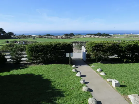 A beautiful, well-cared-for lighthouse with idyllic views of the golf course, dunes, and sea, and a garden with bright flowers.