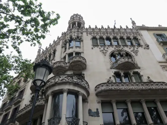 Elegant boulevard with Catalan Modernist lampposts and high-end stores.