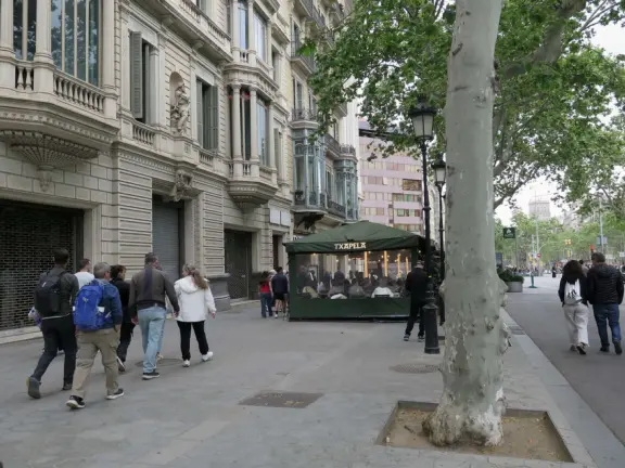 Elegant boulevard with Catalan Modernist lampposts and high-end stores.