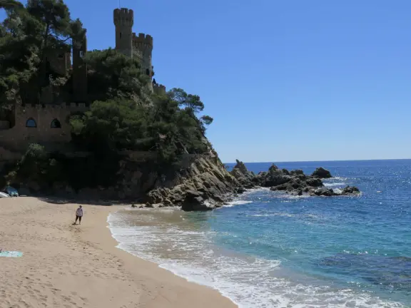 Idyllic town with cafes looking out on the ocean, castle that looks like a fairytale above the beach, and pretty square with a modernist architecture mosaic tiled church.