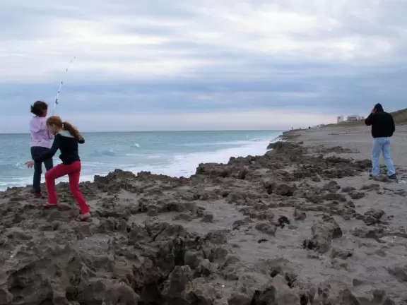 Kids playing on the limestone rock at the shoreline.