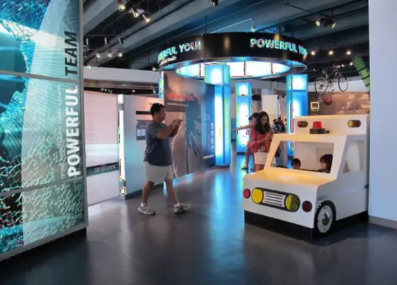 Toddlers climb into and drive an ambulance.