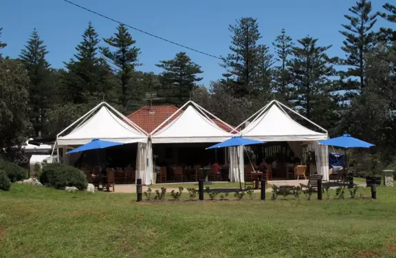 Windy beach with walking paths to high sand dunes and Barrenjoey lighthouse.